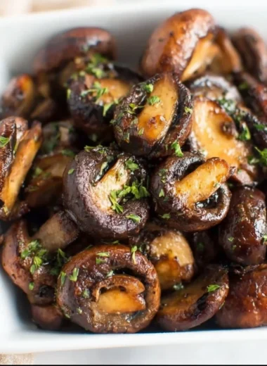 Crispy air fryer mushrooms served in a bowl, garnished with herbs.