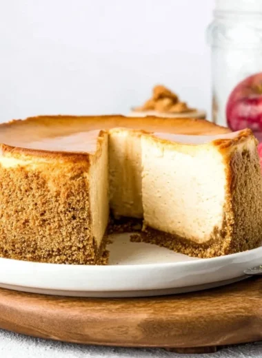 Slice of delicious Apple Cider Cheesecake with a golden apple topping