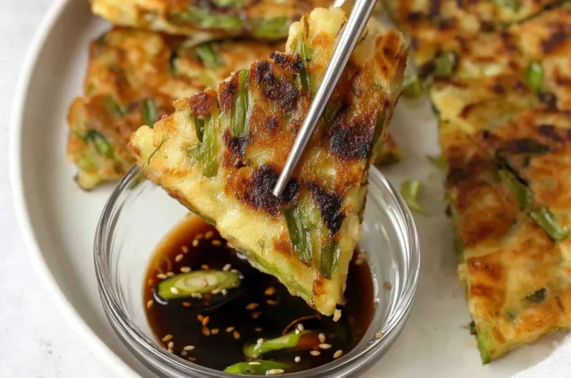 Korean scallion pancake served with dipping sauce on a plate