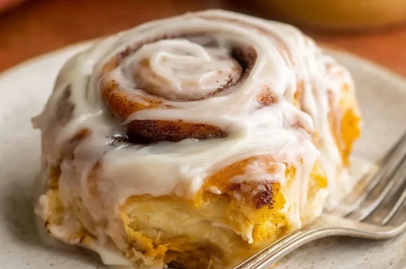 Delicious homemade pumpkin cinnamon rolls topped with creamy icing.