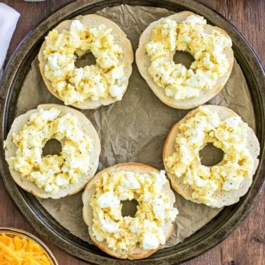 Homemade breakfast pizza bagels topped with eggs, cheese, and vegetables.