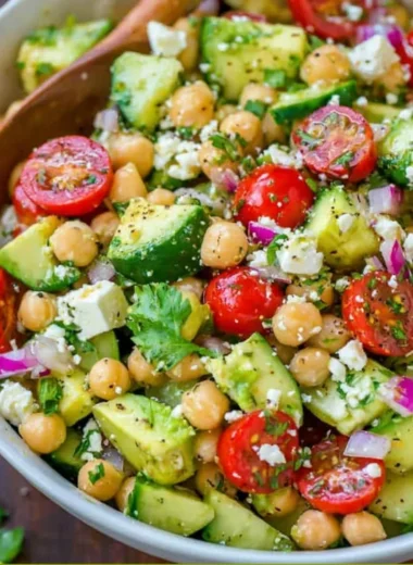 Colorful chickpea salad with vegetables and dressing in a bowl