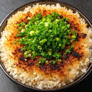 A plate of delicious crispy rice garnished with herbs and spices.