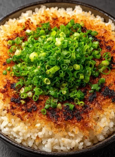 A plate of delicious crispy rice garnished with herbs and spices.