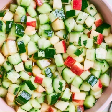 A vibrant Cucumber Apple Salad with fresh ingredients served in a bowl.