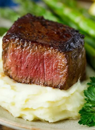 Delicious Filet Mignon topped with Garlic and Herb Butter served on a plate