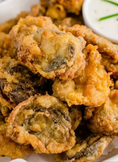 Plate of golden, crispy fried mushrooms ready to be served as a tasty snack