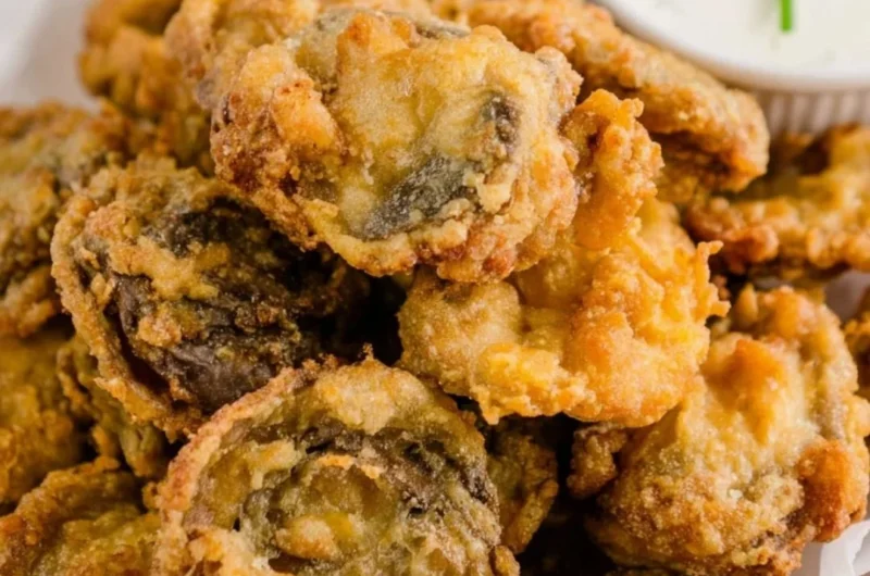 Plate of golden, crispy fried mushrooms ready to be served as a tasty snack