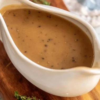Bowl of homemade brown gravy served over mashed potatoes