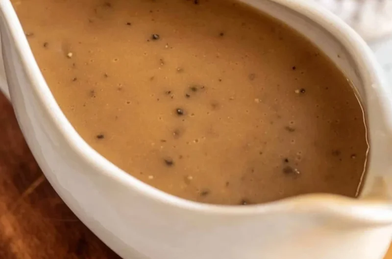 Bowl of homemade brown gravy served over mashed potatoes