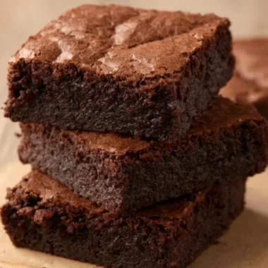 Delicious homemade brownies on a plate topped with chocolate drizzle.