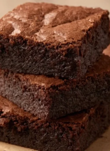Delicious homemade brownies on a plate topped with chocolate drizzle.