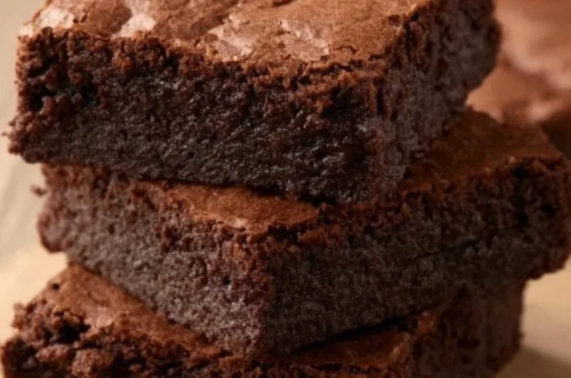 Delicious homemade brownies on a plate topped with chocolate drizzle.