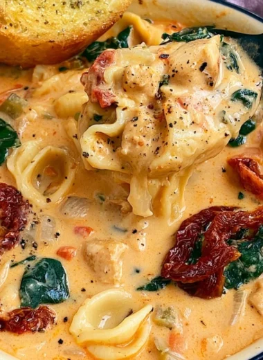 Bowl of Marry Me Tuscan Chicken Soup with fresh herbs and crusty bread