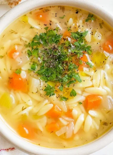A delicious bowl of orzo soup with vegetables and herbs