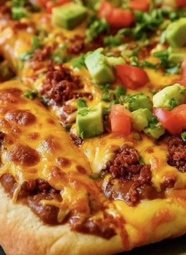 Delicious Taco Pizza with toppings such as ground beef, cheese, and fresh vegetables