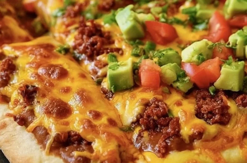 Delicious Taco Pizza with toppings such as ground beef, cheese, and fresh vegetables