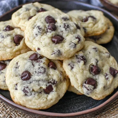Yogurt chocolate chip cookies on a plate, topped with chocolate chips.
