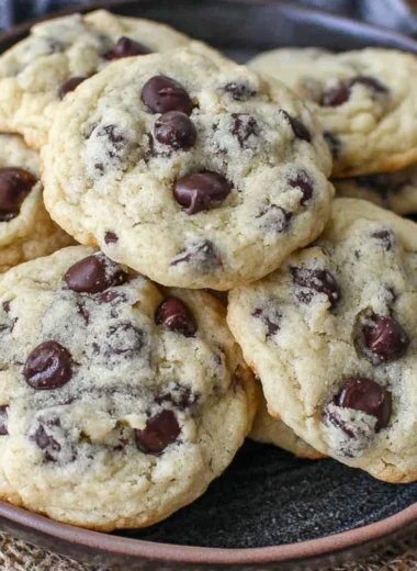 Yogurt chocolate chip cookies on a plate, topped with chocolate chips.