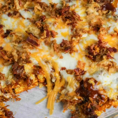 Delicious BBQ Bacon Cheeseburger Frito Pie topped with crispy bacon and cheese