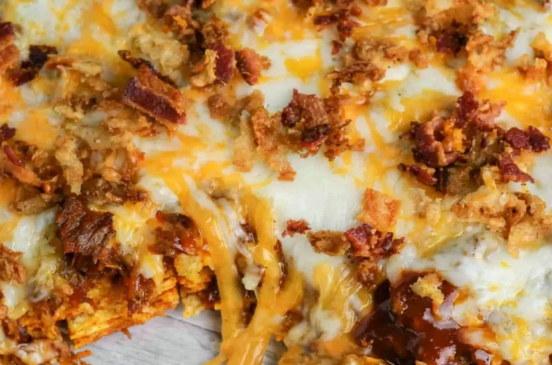 Delicious BBQ Bacon Cheeseburger Frito Pie topped with crispy bacon and cheese