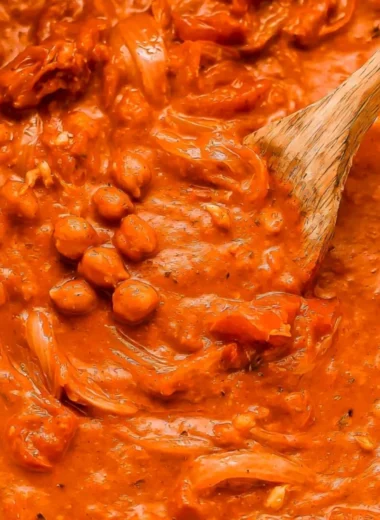 Bowl of creamy coconut chickpea curry topped with fresh herbs