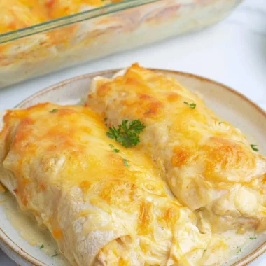 Creamy white chicken enchiladas topped with cheese and cilantro