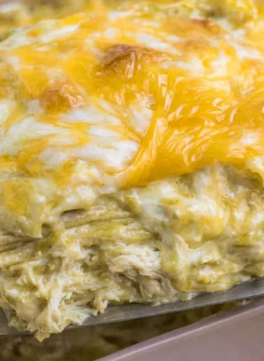 Delicious green chili chicken enchiladas topped with cheese and herbs