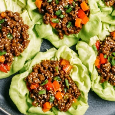 Plate of Ground Beef Lettuce Wraps with fresh vegetables and sauce