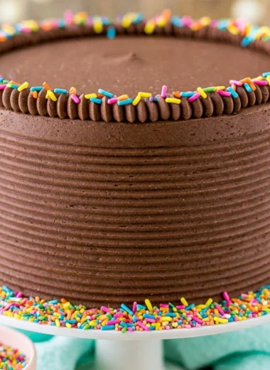 Moist yellow cake with chocolate frosting on a decorative plate