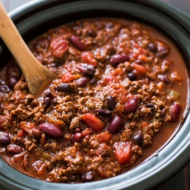 Bowl of hearty slow cooker chili topped with cheese and cilantro