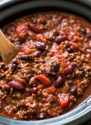 Bowl of hearty slow cooker chili topped with cheese and cilantro