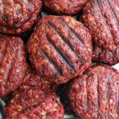 Delicious smoked burgers grilling on a barbecue