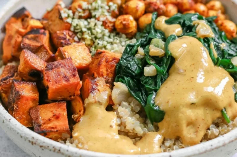 Colorful sweet potato grain bowl topped with fresh vegetables and herbs