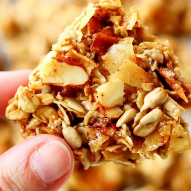 A bowl of crunchy granola topped with fresh fruits and nuts