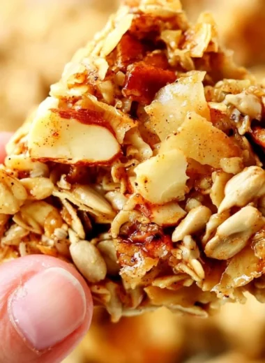 A bowl of crunchy granola topped with fresh fruits and nuts