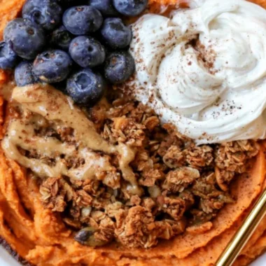 Fluffy sweet potato breakfast bowl topped with nuts and fruits