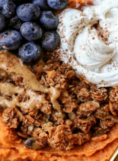 Fluffy sweet potato breakfast bowl topped with nuts and fruits