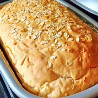Loaf of freshly baked honey oat bread with a golden crust
