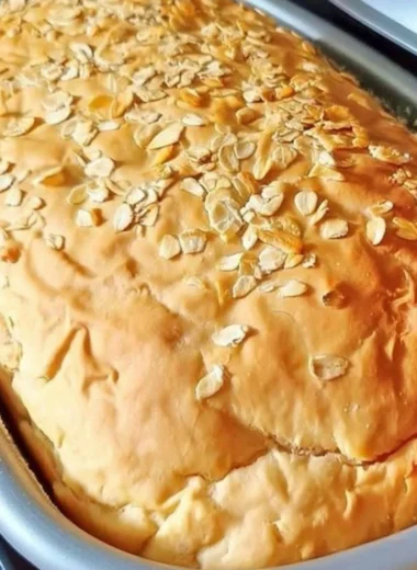 Loaf of freshly baked honey oat bread with a golden crust